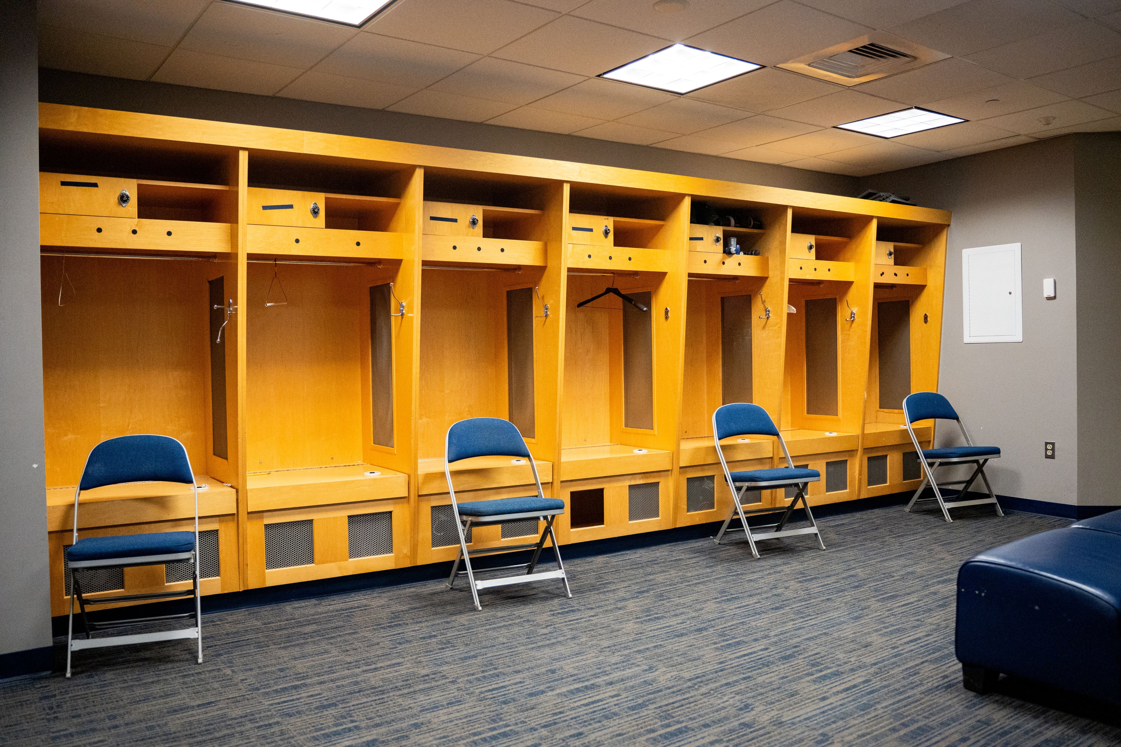 Yellow lockers with blue chairs in the locker room of Gampel Pavilion